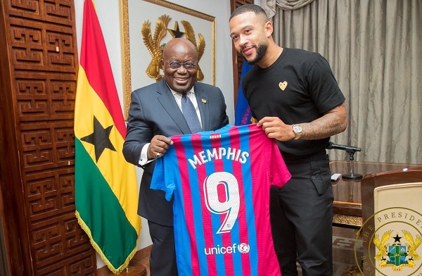 Memphic Depay hands a replica Bercelona jersey to President Nana Addo Dankwa Akufo-Addo Memphic Depay hands a replica Bercelona jersey to President Nana Addo Dankwa Akufo-Addo